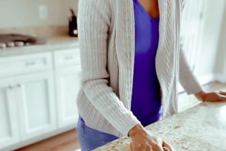 woman wiping kitchen counter with dog watching from the floor